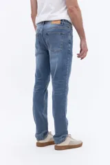 Jean de corte recto y tiro medio con efecto lavado, confeccionado en tejido de algodón con elastano. Presenta cierre frontal con botón y cremallera, bolsillos laterales y traseros, y trabillas para cinturón.