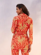 Blazer color crema de manga larga, con solapas amplias y cinturón para ajustar a la cintura.