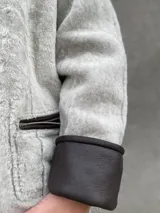 Buzo reversible de cuero color gris claro, con interior de corderito sintético.