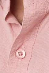 Camisa de manga corta de algodón en color celeste con microdiseño geométrico a cuadros, cuello camisero y bolsillo frontal con logo bordado.