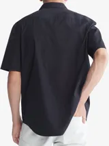 Camisa de manga corta color negro, con cuello camisero y corte holgado.