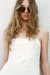 Vestido midi blanco de escote recto y tirantes finos ajustables. Presenta un torso elástico tipo nido de abeja con detalle de flores bordadas al tono en la parte superior y una falda de caída fluida con bolsillos laterales ocultos.