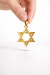 Dije con forma de Estrella de David, realizado en acero con acabado dorado.