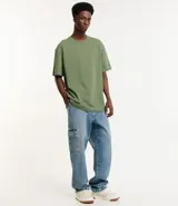 Remera de corte relaxed, confeccionada en algodón de tejido grueso con cuello redondo y mangas cortas.