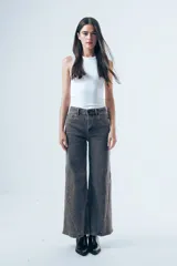 Jean de corte wide leg y tiro alto, con diseño de paneles laterales en el ruedo que aportan amplitud. Confeccionado en denim de tono gris oscuro con efecto lavado.