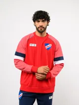 Buzo de cuello redondo del Club Nacional de Football, color azul marino con mangas grises y franjas rojas y blancas en los brazos. Incluye el escudo del club en el pecho y logos de Umbro y BBVA.