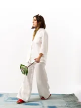 Pantalón de lino blanco de corte holgado, con cintura elástica ajustable con cordón, dos bolsillos laterales y un bolsillo trasero.