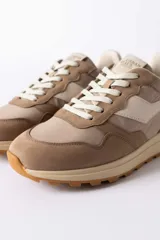 Championes urbanos de diseño técnico, combinando paneles de gamuza y tela en tono verde oliva con detalles en beige y negro. Presentan una suela de plataforma en color crema con base dentada en tono caramelo.