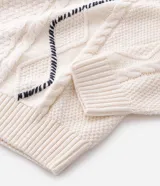 Suéter masculino de cuello redondo y manga larga, confeccionado en una mezcla de algodón y acrílico. Presenta un diseño texturizado con trenzados y detalles de costuras manuales en contraste.
