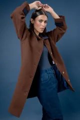 Tapado de corte recto con estampado de pata de gallo en tonos azul y gris. Presenta cuello camisero y detalles en los puños en color negro, cierre frontal con botones y bolsillos laterales.