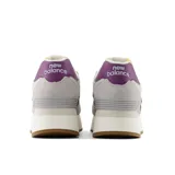 Championes urbanos New Balance modelo 574, color gris claro con detalles en blanco y violeta, confeccionados en gamuza y malla, con logo "N" característico en los laterales, plataforma alta y entresuela ENCAP.