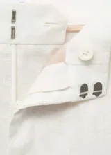 Pantalón de lino color blanco, de corte recto y tiro alto, con bolsillos laterales y traseros, y cierre oculto.