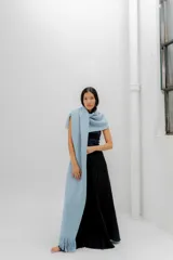 Chal celeste tejido al crochet con flecos en los extremos.