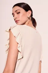 Remera color crema de corte recto con mangas cortas con volados.