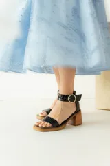 Sandalias de cuero color beige con plataforma y taco cuadrado de madera. Presentan una tira frontal ancha y una tira ajustable en el tobillo con hebilla metálica plateada.