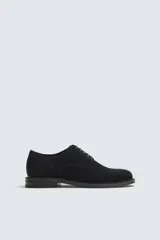 Zapato tipo derby de hombre con cordones, confeccionado en piel con acabado de serraje y horma redonda.