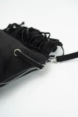 Cartera tipo sobre de gamuza color bordó, con flecos largos laterales y correa larga ajustable.