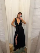 Vestido largo de seda color marrón con acabado brillante, escote en V profundo y detalles en terciopelo negro que enmarcan el escote, la cintura y la abertura frontal.