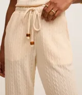 Pantalón zanahoria Marfinno de textura acanalada color beige, con cintura elástica, cordón ajustable con detalles metálicos y bolsillos laterales.