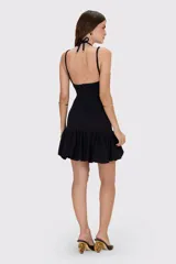 Vestido corto de punto jacquard color negro, con escote profundo, tirantes dobles con apliques dorados en forma de flor y falda con volado tipo globo.
