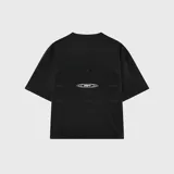 Remera negra de corte oversize, confeccionada en algodón premium con textura suave. Presenta un diseño minimalista con una pequeña estampa de texto en el pecho.