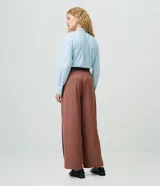 Pantalón wide leg de sastrería confeccionado en crepé, con tiro alto, pliegues frontales y caída recta. Incluye un cinturón de poliuretano con hebilla metálica y detalle de cadena.