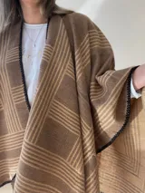 Ruana con diseño a rayas color gris y rosa, con borde de crochet negro.