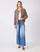 Chaqueta de tweed marca Nanette, color marrón y beige con estampado pata de gallo. Cuello redondo, abertura central, bolsillos delanteros y puños con botones perlados. Terminación desflecada y forro interno.