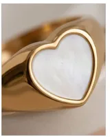 Anillo de acero dorado con diseño de corazón incrustado en nácar blanco.