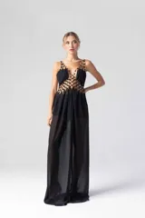 Vestido largo negro de gasa transparente con bordados dorados en el corpiño y tirantes finos.