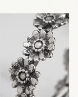 Anillo de plata 925 con diseño de cinta formado por una serie de flores pequeñas unidas entre sí.