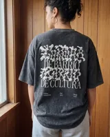 Remera de algodón con efecto lavado stone wash, de corte oversize y manga corta. Presenta un diseño gráfico estampado en la espalda con tipografía artística y texto alusivo a la cultura de barrio.