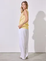 Blusa amarilla sin mangas de lino y rayón, con cuello a la base y escote en V, abertura central con botones y terminación anudada.