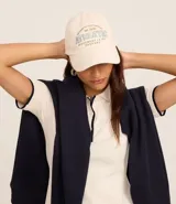 Gorra color crema con bordado frontal de la palabra "Athletic" en celeste.