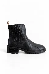 Botín de cuero color negro, de estilo Chelsea con paneles elásticos laterales y suela track con taco bajo y plataforma estriada. Cuenta con una presilla marrón en la parte posterior.