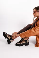 Borcegos de cuero vacuno color negro, beige y marrón claro, con cordones negros, suela de goma track color negro y plataforma de 5 cm.