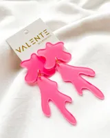 Aros colgantes de acrílico fucsia con forma abstracta.