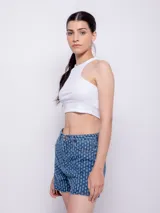 Short de jean azul con textura de roturas, tiro alto, cinco bolsillos, botón y cierre metálico.