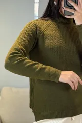 Buzo de punto con cuello alto, diseño de textura acanalada en el frente y mangas largas con puños ajustados.