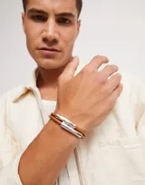 Pulsera doble de cuero color camel con piezas tubulares bañadas en plata de ley y cierre magnético.