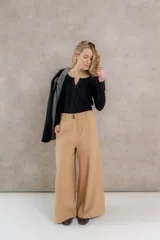 Pantalón sastrero color beige, de tiro medio alto confeccionado en tela de pantalonería, con corte ancho, bolsillos delanteros y traseros.