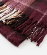 Bufanda de punto con diseño de cuadros escoceses en tonos bordó, marrón y beige, con terminación de flecos en los extremos.