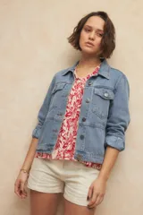 Blusa con estampado floral en color rojo sobre fondo crema, con cuello mao decorado con pequeños volados y cierre frontal parcial.