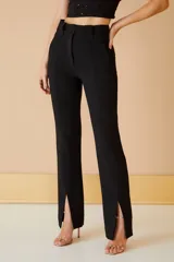 Pantalón negro de vestir con corte recto y aberturas en el ruedo.