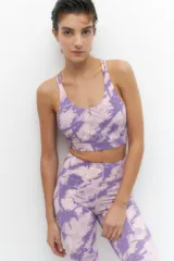 Calza deportiva de tiro alto con estampado tie-dye en tonos violeta y lila, confeccionada en tejido elástico y transpirable.