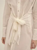 Vestido camisero largo negro con botones nacarados, lazo en la cintura y detalle de Polonio en cobre.