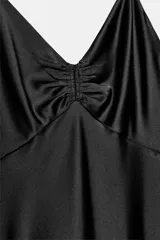 Vestido midi de satén color negro, con escote en pico, tirantes finos ajustables y detalle drapeado en el centro del pecho.