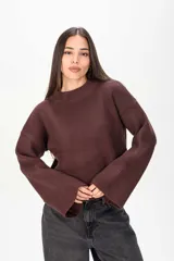 Sweater de tejido de punto color marrón, con cuello redondo y mangas largas anchas de tipo acampanado.