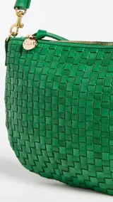 Bandolera verde de cuero tejido con correa de hombro ajustable y cierre de cremallera.