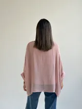 Sweater de punto en color rosado, con diseño holgado, cuello redondo y mangas murciélago anchas con vuelta.